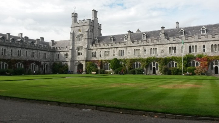 green grass in the quad at University College Cork with university buildings in the background